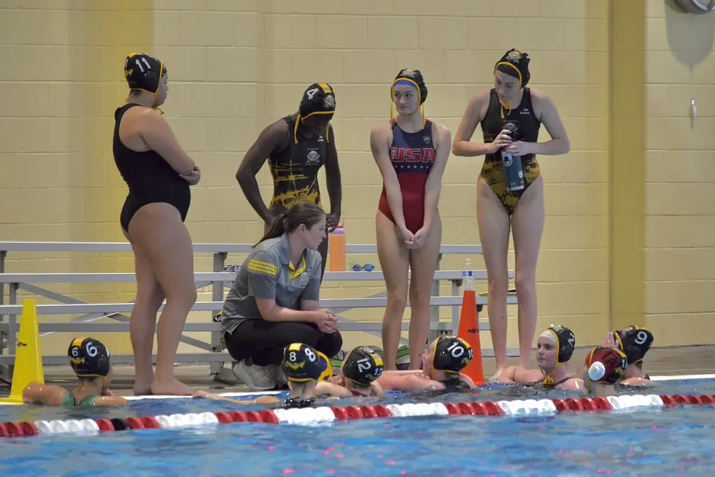 Players watching a game from the side of the pool
