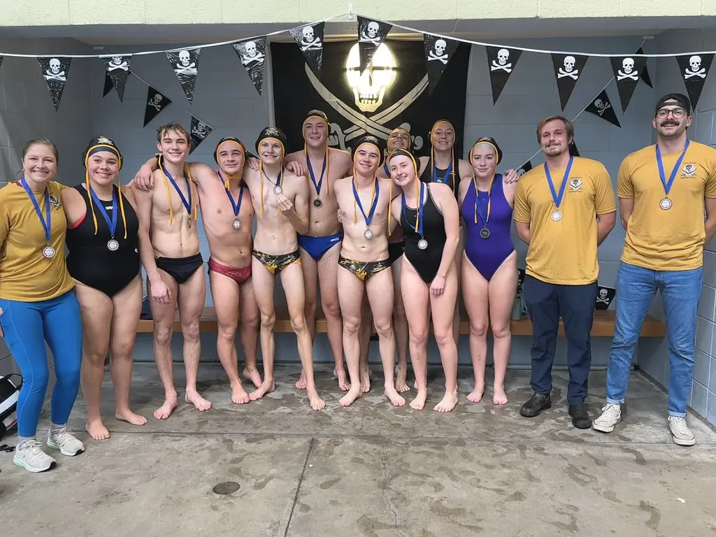 The team with their medals in front of the club's jolly roger banners
